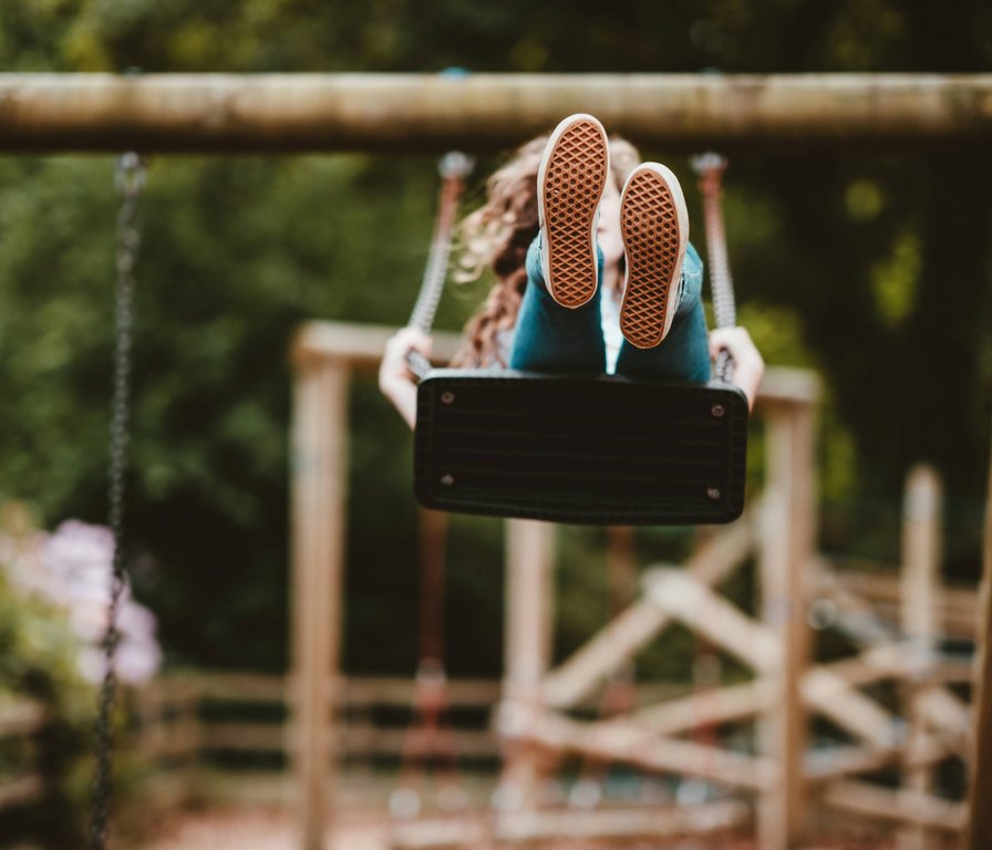 Dziecko na huśtawce na placu zabaw